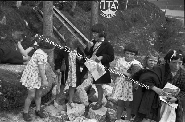 CHILDREN WAITING IN GROUP AT SIDE OF ROAD